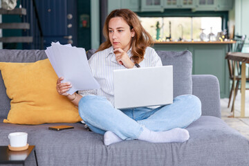Young freelancer woman get over paperwork while working from living room