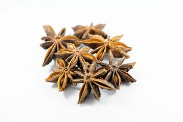 Close-up shot of a pile of star anise on a white background