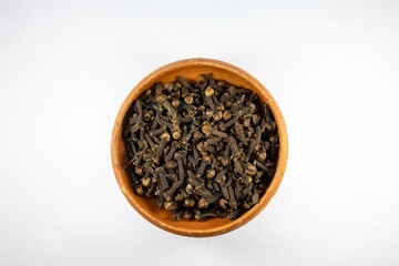 Closeup of dried cloves in the bowl on the white background