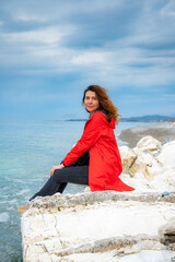 girl in a red jacket on the seashore - 768827803