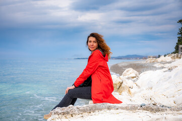 girl in a red jacket on the seashore - 768827829