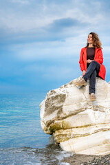 girl in a red jacket on the seashore - 768827863