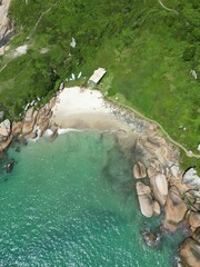Aerial view of a beach with greenery and rocks