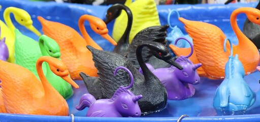A container full of colorful swan toys arranged in an organized manner