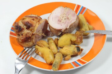 Mixed chicken kebabs with fried battered vegetables on a plate against a white background.