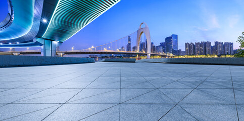 Empty square floor and bridge with modern city buildings at night in Guangzhou