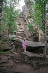 Woman in the taiga forest and rocks of the Stolby nature reserve park