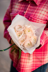 Bouquet of light roses in white matte wrapping paper
