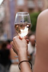 a woman's hand holding a glass of white wine
