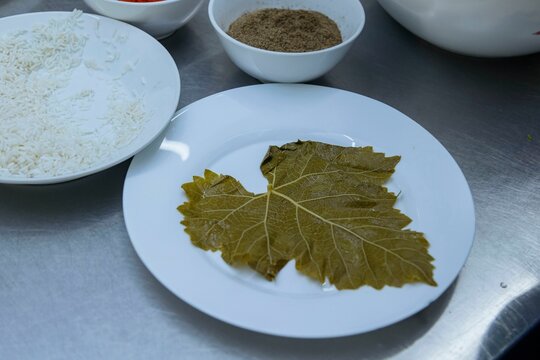 Isolated, white plate displaying steamed white rice, various leaves