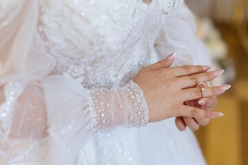 Woman delicately placing a sparkling wedding ring onto the finger of her opposite hand