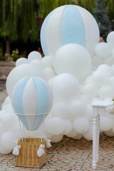 Collection of white balloons and blue hot air balloons for a baby gender reveal party
