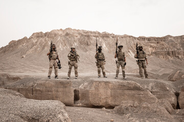 Soldiers in camouflage uniforms aiming with their rifles.ready to fire during military operation in...