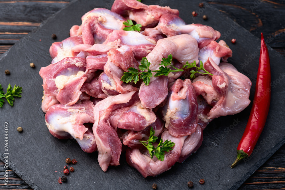 Poster raw chicken giblets gizzard ( stomach ) , meat background