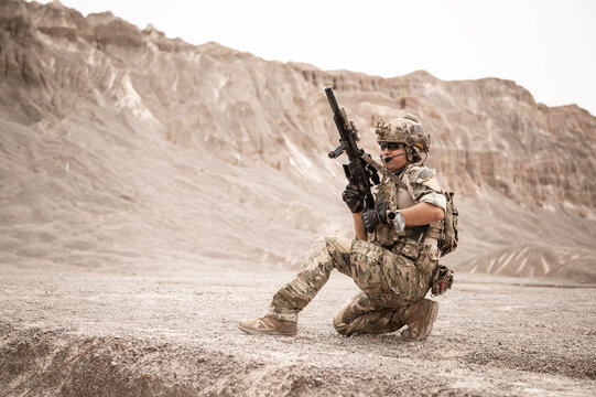 Soldiers in camouflage uniforms aiming with their rifles.ready to fire during military operation in the desert , soldiers training  in a military operation