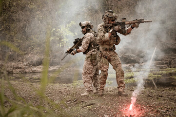 Soldiers  in camouflage uniforms aiming with their rifles.ready to fire during Military Operation...