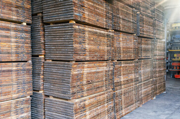 Stacks of wooden pallets. Interior of production warehouse. Plant for production of paving slabs.