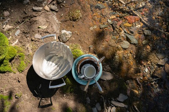unwashed dishes on the beach of river