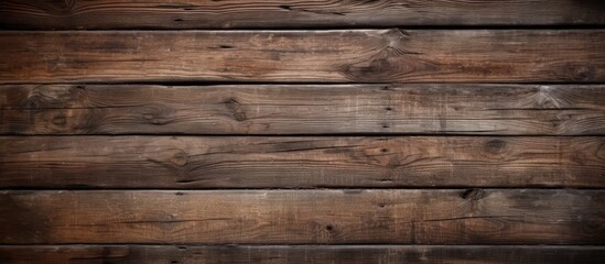 A close-up view of weathered brown wooden panels standing out starkly against a dark black background. The texture and grain of the old wood are visible, adding depth and character to the composition.