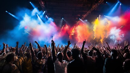 Audience watching a live music concert with colorful stage lights and smoke in the background