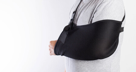 A man's arm in a black bandage for immobilization of the elbow joint after an injury. Bandage for...