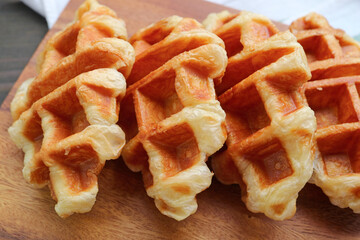 Delectable Freshly Baked Heap of Croffle or Croissant Waffle on Wooden Breadboard