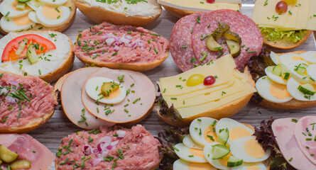 Diverse belegte Brötchen zum Frühstücken mit Käse, Ei, Fleischsalat, Mett, Mettwurst, Aufschnitt, Gurke, Tomate