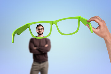 Man holding oversized green glasses