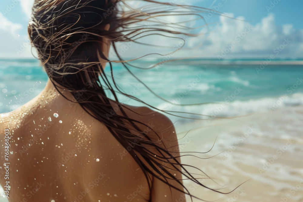 Wall mural young woman with long windy hair enjoying the breeze at beach. beautiful girl relaxing at beach duri