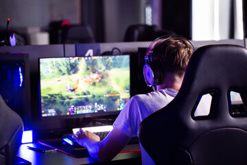 Serious focused teen gamer in headset playing PC video game at computer club during cyber sport tournament. E-sport championship. Modern multiplayer online real-time strategy RTS, tactics skill - 768870481