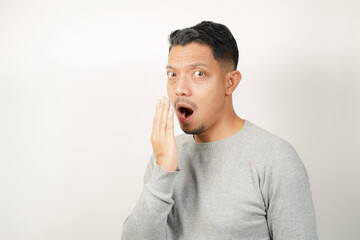 Funny facial expression bad breath with hand covering mouth of Asian man