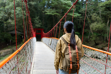 Hiking woman walk along the suspension bridge