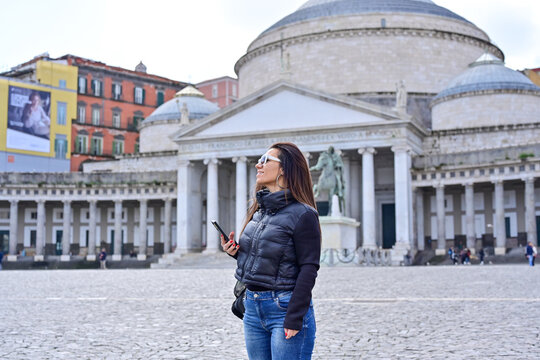  Naples,Italy, Piazza del Plebiscito. Young beautiful woman  using a mobile phone taking a pictures.Concept of Italian gastronomy and travel