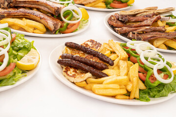 grilled sausages and halloumi with french fries and salad