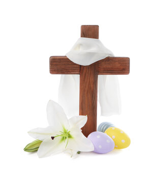 Wooden cross, cloth, painted Easter eggs and lily flowers on white background