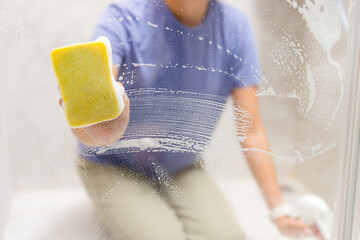 Sponge clean the glass of windows in bathroom