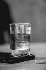 Detailed view of little glass with swirling and sparkling drink (in black and white)