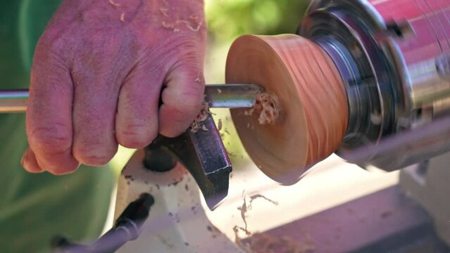 turnery of a wooden bowl with spiral sawdust shavings with hand and chisel. High quality 4k footage