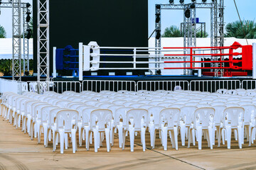 Boxing ring and many chairs for spectators prepared for competition, Outdoors. Sport and empty...
