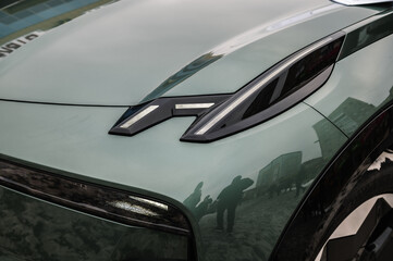 The right front light on a new modern electric sedan car. Modern concept supercar exterior design detail - headlight. Right turn indicator signal. Front lights closeup. Concept of future.