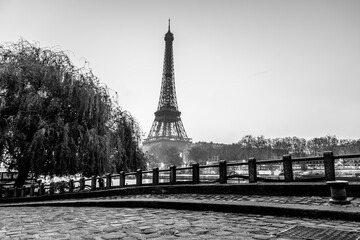 A black and white photo of the Eiffel Tower in Paris, France. The image has a moody and nostalgic feel, as it captures the tower at dusk