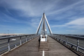 Papier Peint photo autocollant Atlantic Ocean Road Bridge with wooden pedestrian walkway floor with paint marks and metal braces to support the structure on a day with blue skies