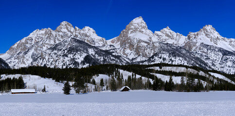 Teton Mountain Range in Wyoming Cabin in Winter Blue Sky and Forest