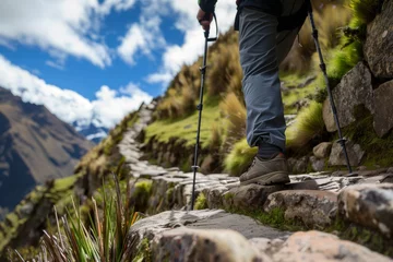 Fotobehang walker using hiking poles on a steep terrace incline © studioworkstock