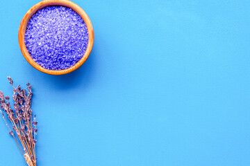 purple spa salt for aroma therapy with lavender flower fragrance on blue background top view copyspace