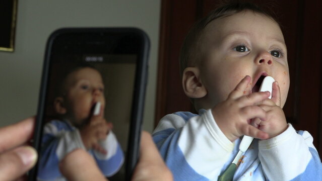 Parent taking photo of baby with smartphone