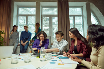 Young boys and girls, student meeting in university library for studying and doing projects together. Concept of education, youth, knowledge, homework, exams, projects.