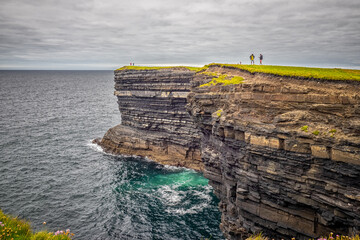 Cliff near Downpatrick Head - Two People Standing on Cliff Overlooking Ocean