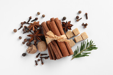 Different spices, nuts and fir branch on white table, flat lay