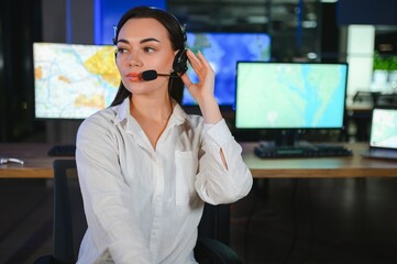 Friendly smiling woman call center operator with headset using computer at office